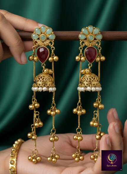 Pink and green floral long dangler jhumka earrings with gold finish, pearl detailing and ghungroo chains.