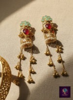 Pink and green floral long dangler jhumka earrings with gold finish, pearl detailing and ghungroo chains.