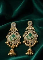 Green enamel and gold-tone Kashmiri jhumka earrings with intricate design and sparkling stones.